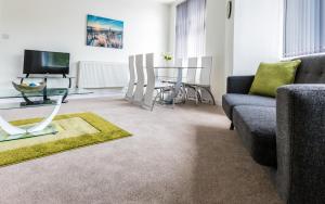a living room with a couch and a table at Comfortable Swindon Town Centre Apartments, FREE Parking, sleeps up to 8 in Swindon