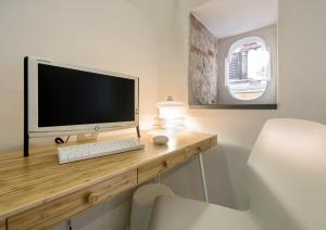 uma secretária com um monitor de computador e um teclado e rato em Castelletto Suite La Marina em Cagliari