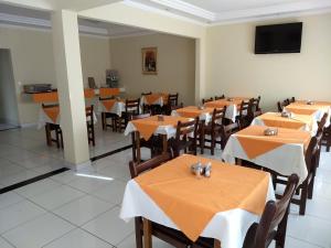 une salle à manger avec des tables et des chaises et une télévision à écran plat dans l'établissement Hotel Telles, à Hortolândia