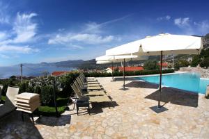 una piscina con sombrillas y tumbonas junto a una piscina en Hotel Villa Gustui Maris en Cala Gonone