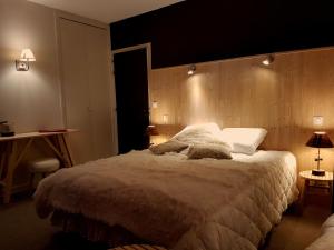 a bedroom with a large bed with a wooden headboard at Le Pavillon in La Bourboule