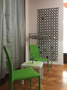 a living room with two green chairs and a table at Rooms Portorose Center in Portorož