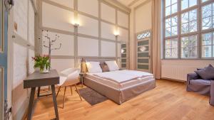 ein Schlafzimmer mit einem Bett und einem Schreibtisch in einem Zimmer in der Unterkunft Anno 1433 Hotel Lüneburg in Lüneburg