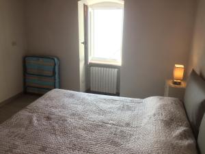 een slaapkamer met een bed en een raam bij Appartamento cadelagnel in Castelletto di Brenzone
