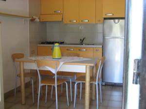 ヴィッラシミーウスにあるVillino Claudiaのキッチン(テーブル、椅子、冷蔵庫付)