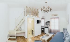 a living room with a blue couch and a staircase at Viva Mare Traditional Studios in Astypalaia