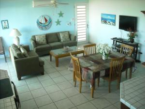 ein Wohnzimmer mit einem Sofa, einem Tisch und Stühlen in der Unterkunft Ocean View Apartment in Rio Grande