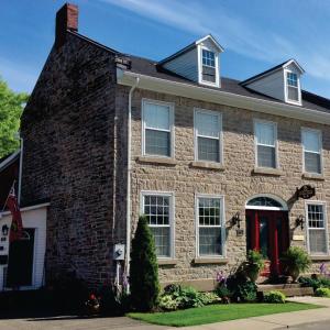 ceglany dom z czerwonymi drzwiami w obiekcie Sir Isaac Brock B&B Luxury Suites w mieście Brockville