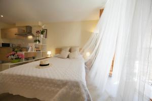 a bedroom with a white bed with a hat on it at El Faro Apartaments in Tarragona
