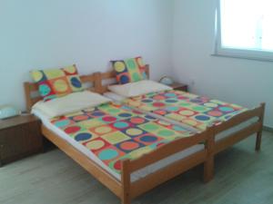 a large bed with a colorful comforter in a bedroom at Apartman Put in Baška