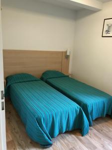 dwa łóżka siedzące obok siebie w pokoju w obiekcie Appartement T3 Luchon w mieście Luchon