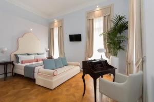 トリエステにあるResidenza Degli Artistiのベッドルーム1室(ベッド1台、ソファ、椅子付)