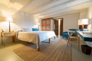 a bedroom with a white bed and a blue couch at Hotel del Teatre - Adults Only in Regencós +43 photos