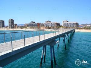 a boardwalk over the water near the beach at LG Big Flat Barcelona in Badalona