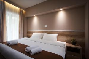 コパオニクにあるGuesthouse Juniorの大きなベッドとタオル2枚のある寝室