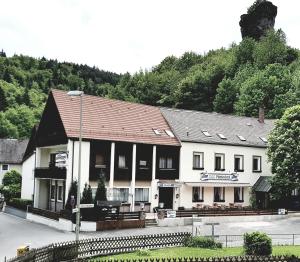 un edificio bianco con tetto marrone su una strada di Pension-Puttlachtal a Pottenstein