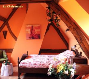 a bedroom with a bed in an attic at B&B La Gentilhommière de Normandie in Sainte-Barbe-sur-Gaillon