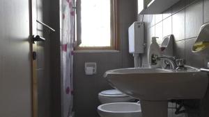 a bathroom with a sink and a toilet and a window at Casa a Villaggio Paradiso in Santa Cesarea Terme