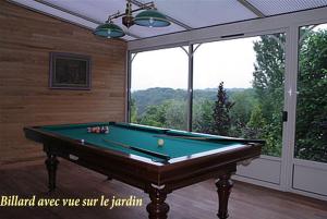 a room with a pool table in front of a window at B&B La Gentilhommière de Normandie in Sainte-Barbe-sur-Gaillon