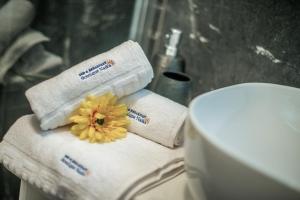 łazienka z ręcznikami i kwiatem na górze toalety w obiekcie Hotel Boutique Natka w Rovinj +37 zdjęć