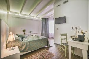 a bedroom with a bed and a desk and a tv at Hotel Boutique Natka in Rovinj