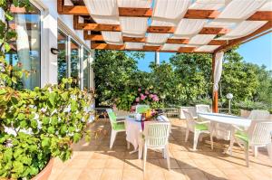 un patio avec des tables, des chaises et des plantes dans l'établissement Guest House Ero, à Sukošan