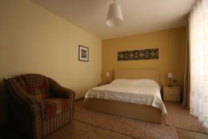 - une chambre avec un lit et une chaise dans l'établissement Apartment Plaisir, à Pogradec