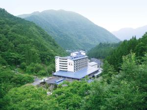 a large building in the middle of a mountain at Okuhida Garden Hotel Yakedake in Takayama