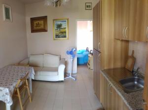 a kitchen with a couch and a table in a room at Casa a Villaggio Paradiso in Santa Cesarea Terme