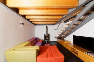 a living room with a couch and a flat screen tv at Antiga Casa da Burra in Viseu