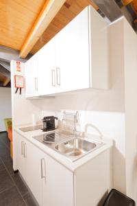 uma cozinha com armários brancos e um lavatório em Antiga Casa da Burra em Viseu
