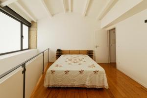 a bedroom with a bed in a room with a window at Antiga Casa da Burra in Viseu