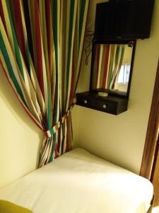 カイロにあるCairo Golden Plaza Hostelのカーテンと鏡とベッドのある部屋