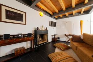een woonkamer met een open haard en een bank bij Antiga Casa do Boi in Viseu