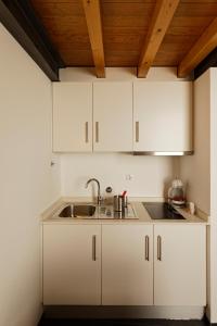 Una cocina con gabinetes blancos y un fregadero. en Antiga Casa do Boi, en Viseu 10 fotos más