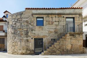 een stenen gebouw met een deur en een trap bij Antiga "Casa do Porco" in Viseu