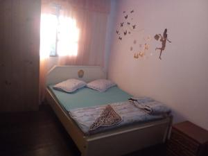 1 cama pequeña en un dormitorio con mariposas en la pared en Rede Savanna, en Penha