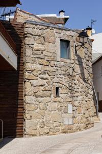 - un bâtiment en pierre avec une fenêtre sur le côté dans l'établissement Antiga "Casa do Porco", à Viseu