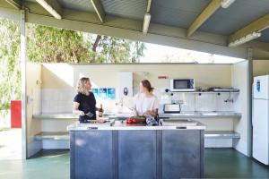 two women standing in a kitchen preparing food at NRMA Victor Harbor Beachfront Holiday Park in Victor Harbor