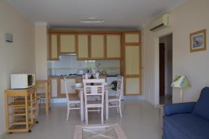 a kitchen and living room with a table and chairs at Vila Marachique in Alvor