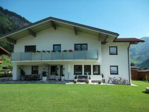 ein Haus mit Balkon und Rasen in der Unterkunft Ferienwohnung Prantner in Rauris