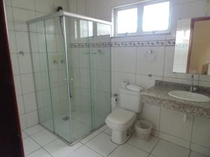 a bathroom with a shower and a toilet and a sink at Hotel Makarena in Três Corações +17 photos