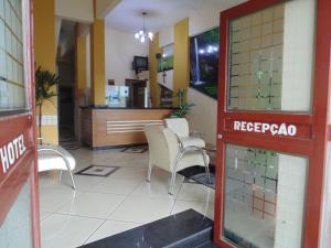 a waiting room with chairs and a counter in a building at Hotel Makarena in Três Corações