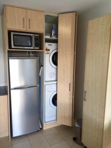 eine Küche mit einem Kühlschrank und einer Mikrowelle in der Unterkunft Merivale Apartments in Christchurch