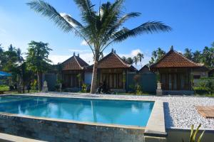 a swimming pool in front of a villa at Wani Bali Resort in Nusa Penida