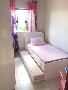 a small bedroom with a bed and a window at Casas Label - Casa B in São Thomé das Letras