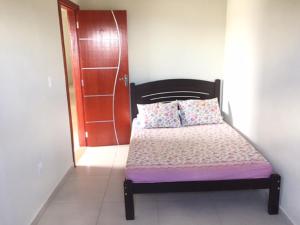 a bedroom with a bed with a wooden headboard at Casas Label - Casa B in São Thomé das Letras