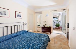 a hotel room with a bed and a dresser at Hotel Senaria in Anacapri