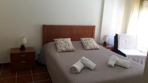 una camera da letto con un letto con tre cuscini sopra di Estrela do Mar - 100m da praia a Peniche