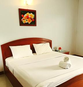 Un dormitorio con una cama con una toalla. en Panchan Place en Ubon Ratchathani